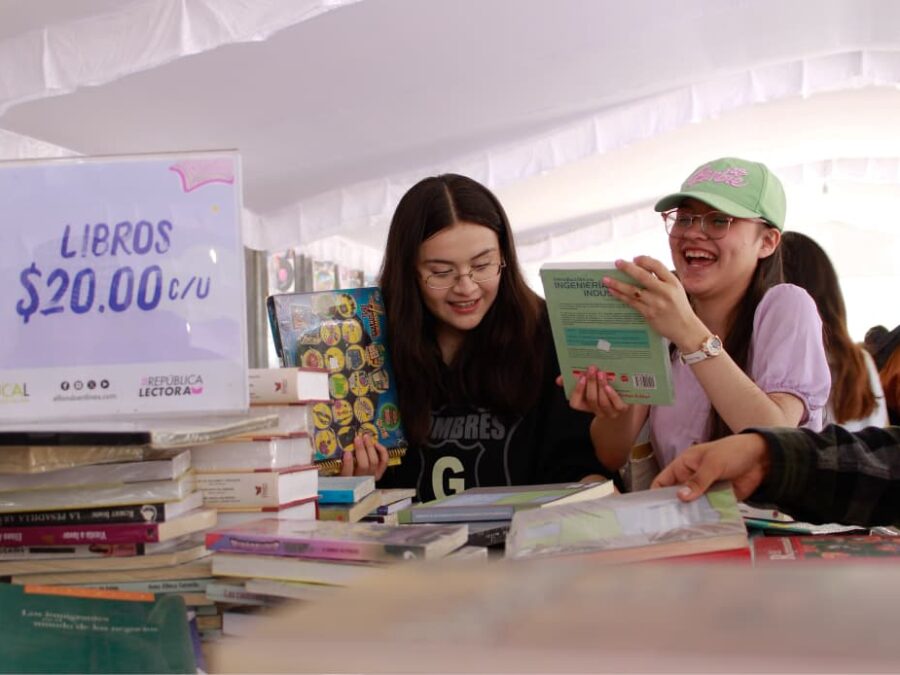 Jóvenes revisan libros durante el 22º Gran Remate de Libros, Discos y Películas en el Monumento a la Revolución